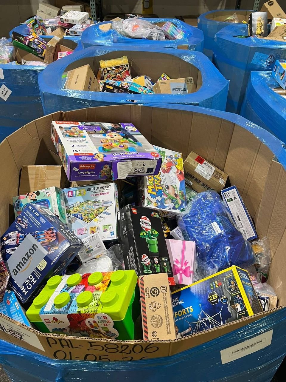 Mixed toy wholesale pallets with boxed games learning toys and play sets in warehouse bins