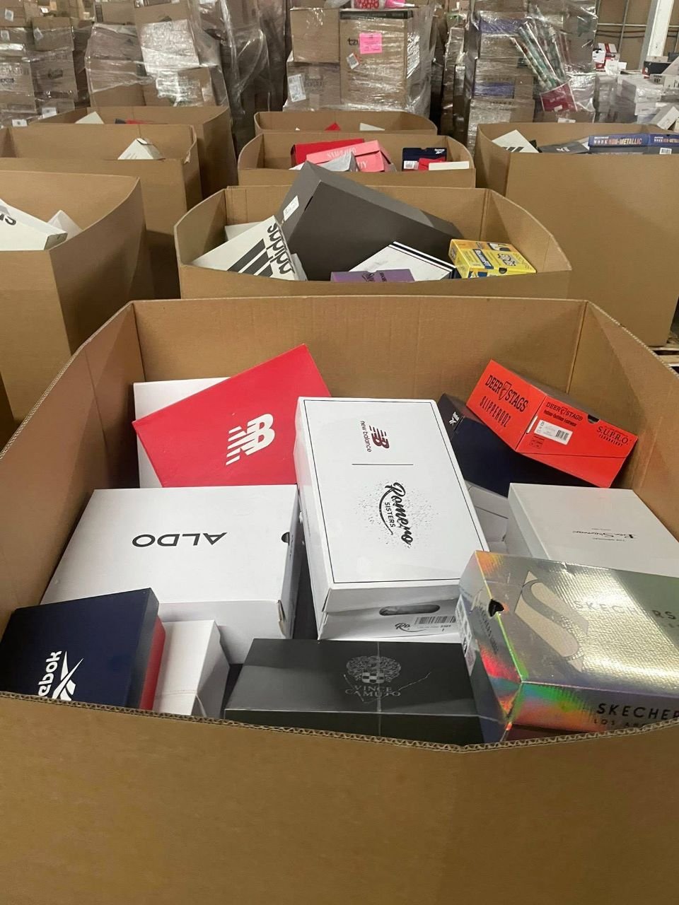 Warehouse scene with assorted shoe pallets and branded footwear packaging