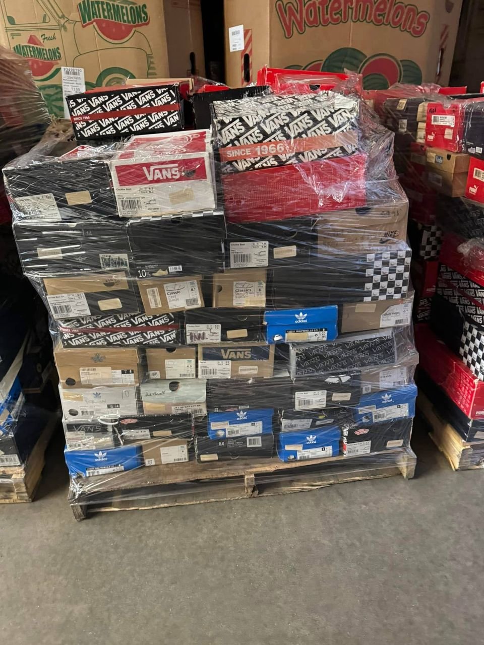 Wrapped wholesale shoe pallet with Vans and adidas boxes stacked on a wood pallet