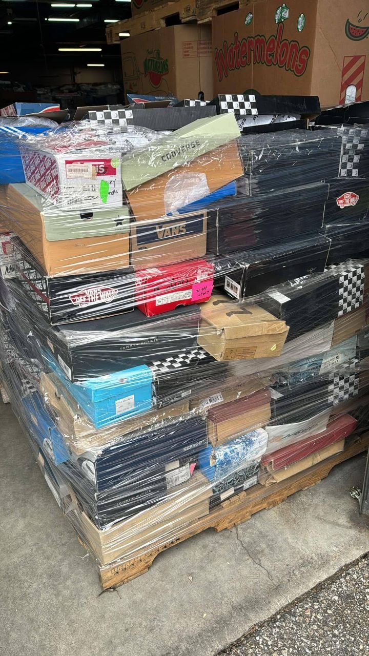 Side view of shrink wrapped branded shoe pallet with Vans and other footwear boxes