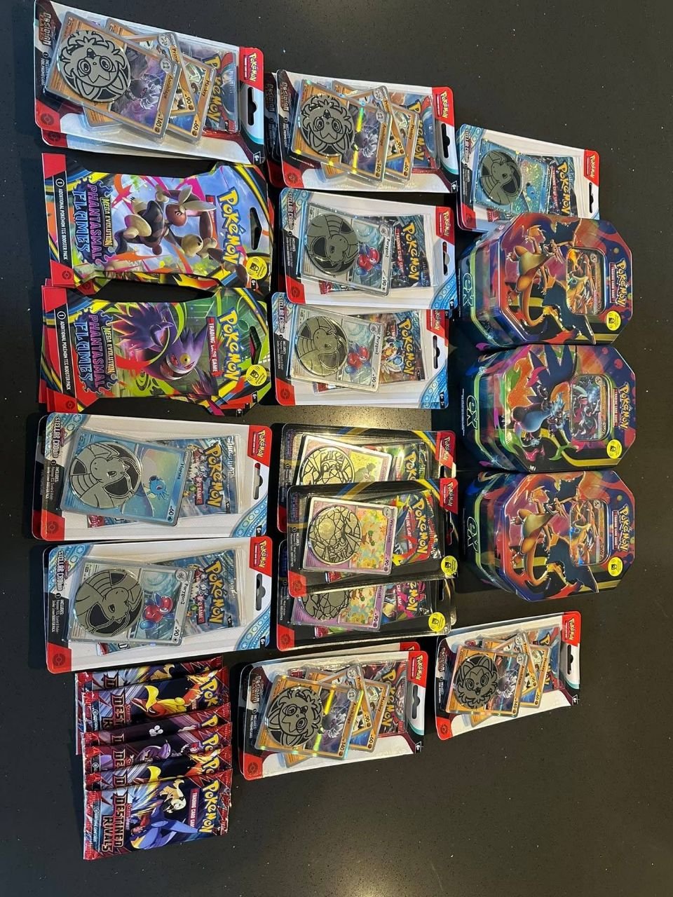 Assorted Pokémon TCG sealed retail packs promo coin sets and collectible tins