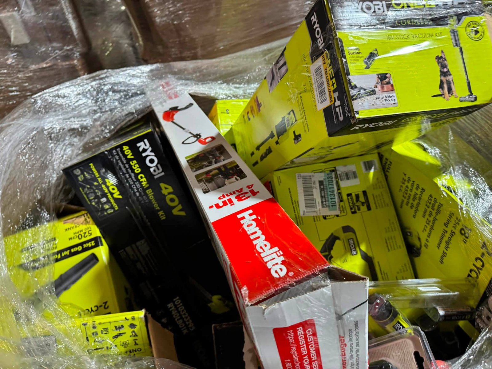 Mixed RYOBI tool pallet including outdoor blowers and Homelite trimmer packaging