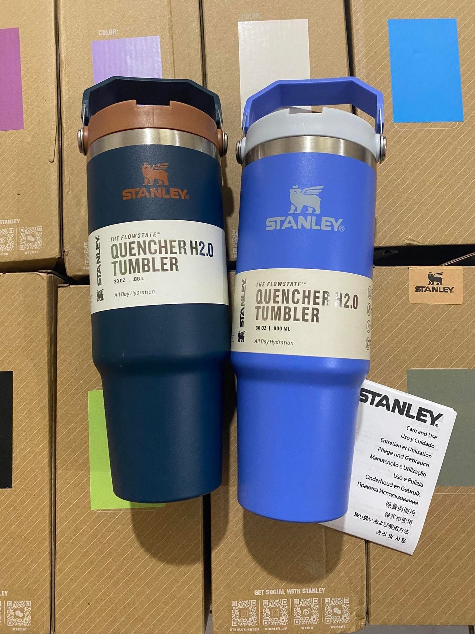 Blue and navy Stanley Quencher 30oz cups against Stanley cartons