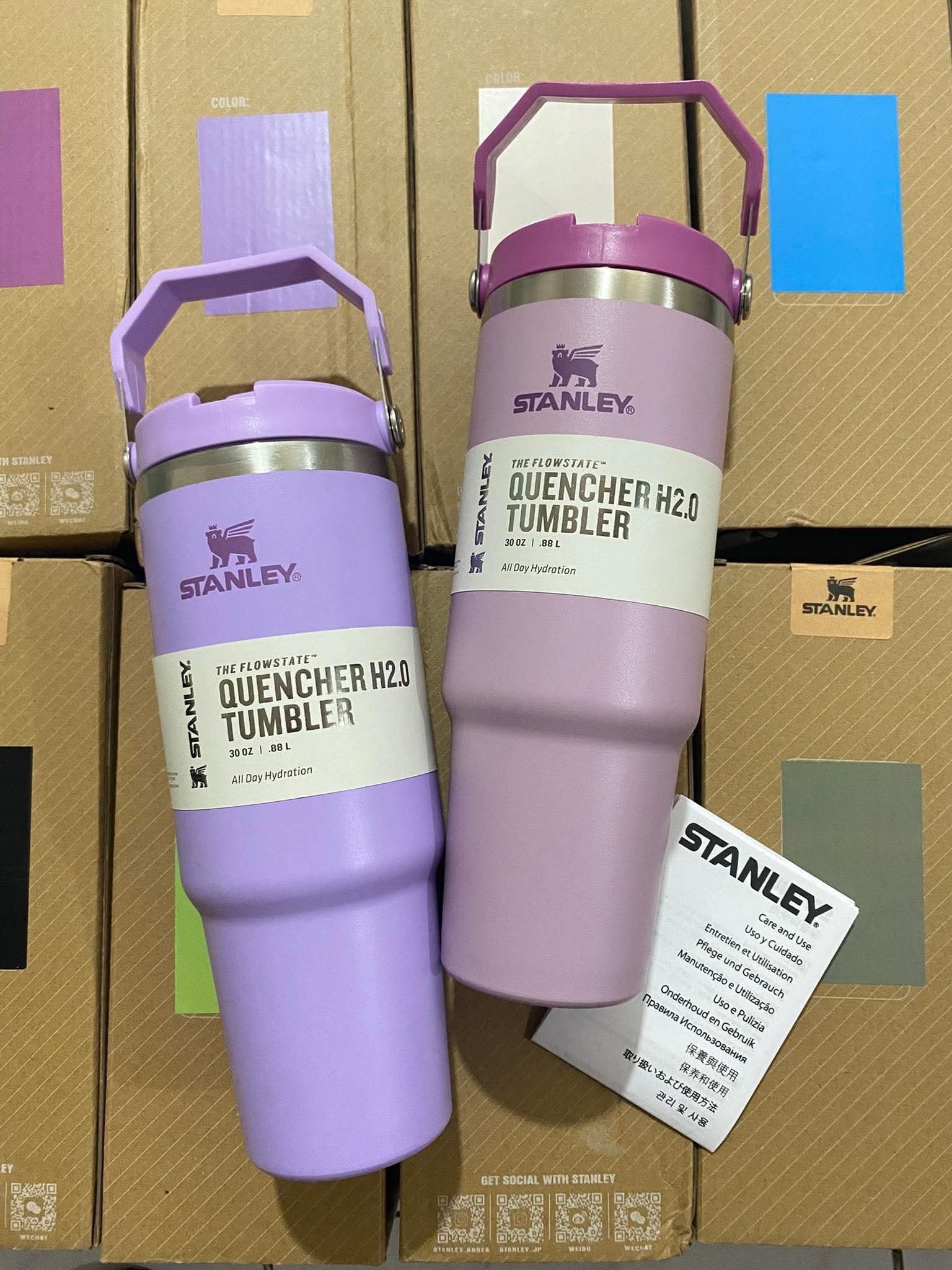 Two purple Stanley Quencher H2.0 30 oz tumblers standing on stacked wholesale cup boxes