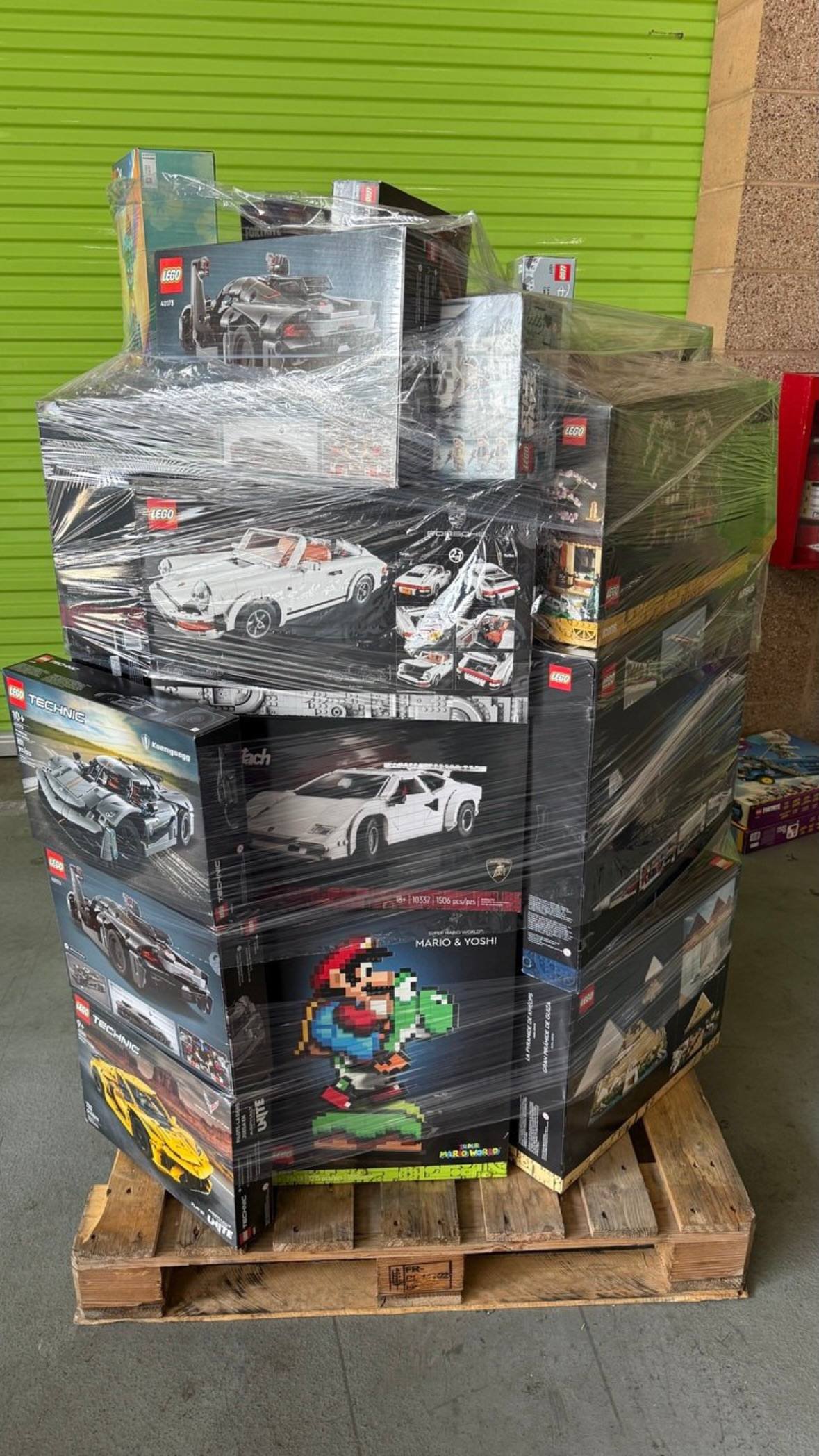 Wholesale boxed LEGO building sets stacked and stretch-wrapped on warehouse pallet